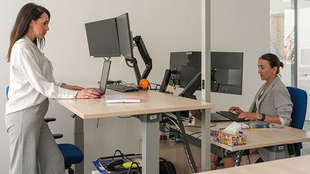 Dvije kolegice rade za ergonomskim stolovima