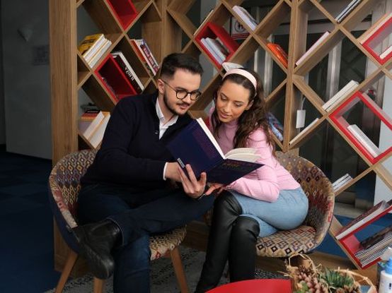 Kolegica i kolega čitaju knjigu